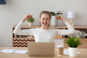 a happy woman using a laptop