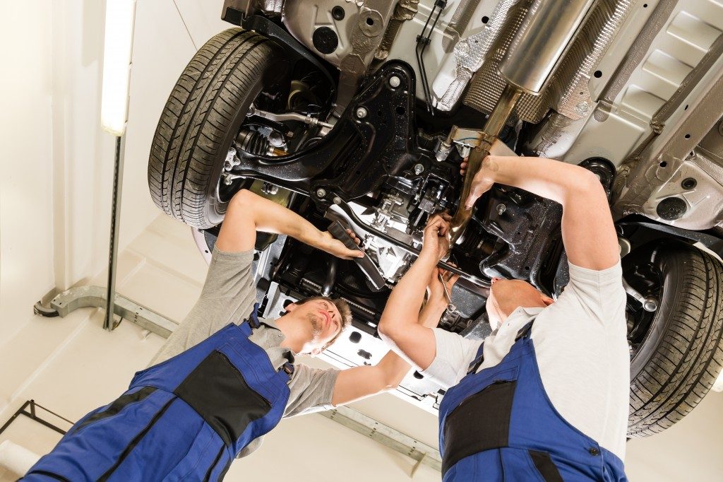 men fixing car engine