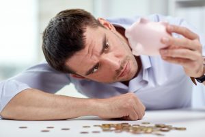 Businessman shaking the piggy bank