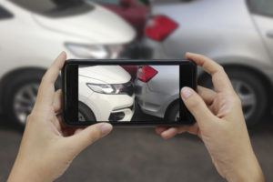 person taking photo of car's damages