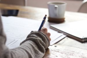 person-writing-on-a-table