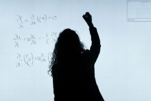 silhouette of a woman writing on a whiteboard